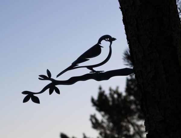 metal bird art hammered into a tree at dusk. These birds are beautiful gardening gift ideas for mom