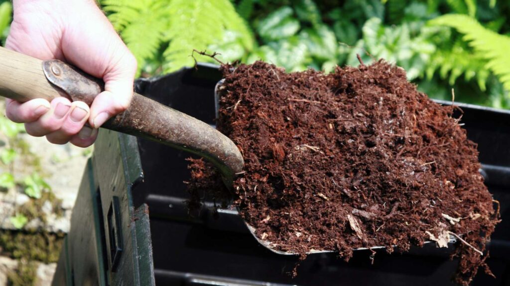 Spade full of nutrient-rich compost, one of the 10 benefits of composting for your vegetable garden