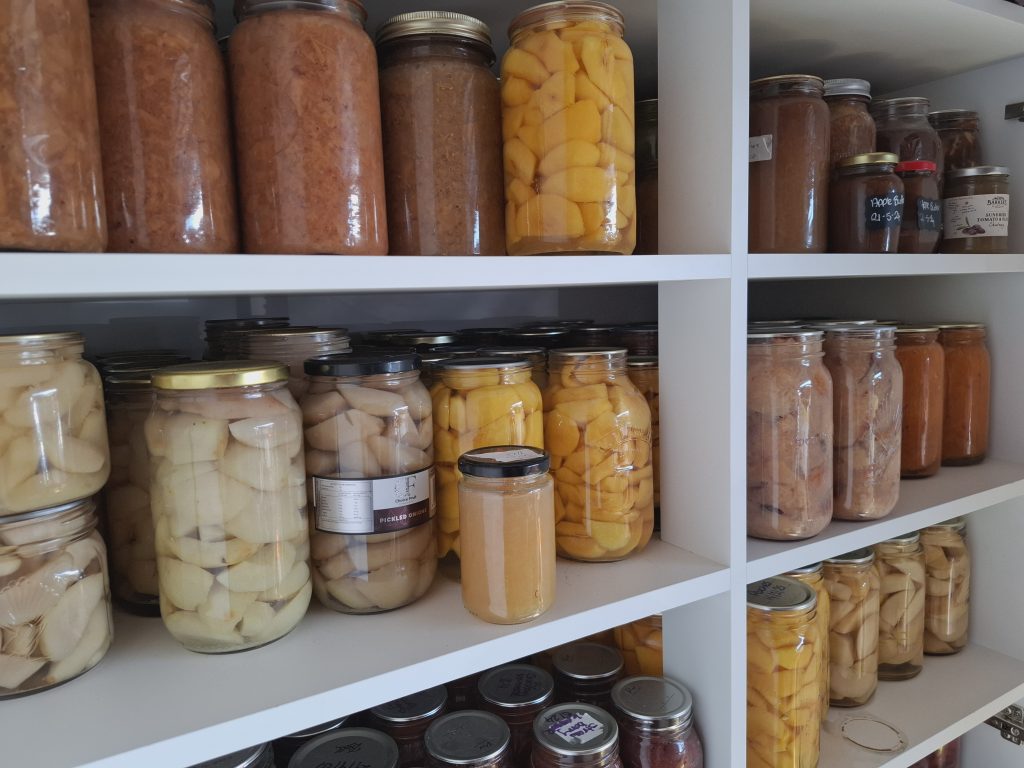 pressure canning and preserved food lined up on a shelf
